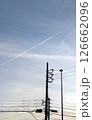 夕暮れの空に伸びる飛行機雲と電線 126662096