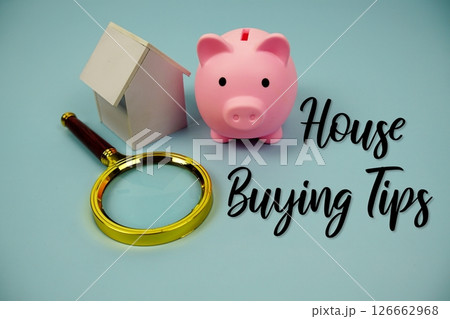 House Buying Tips text with house model, magnifying glass and piggy bank on blue background 126662968