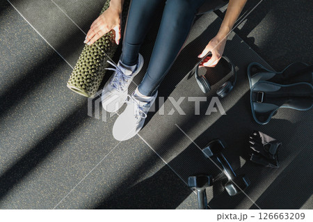 Girl and black dumbbells for sports, ankle weights, headphones, massage roller Girl and black dumbbells for sports, ankle weights, headphones, massage roller 126663209