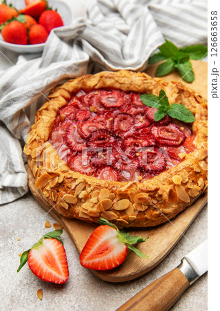Delicious homemade strawberry galette with almond petals and fresh mint Delicious homemade strawberry galette with almond petals and fresh mint 126663658