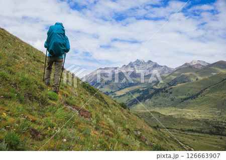 Woman backpacker hiking on high altitude mountains top Woman backpacker hiking on high altitude mountains top 126663907
