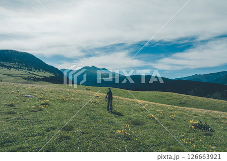 Woman riding mountain bike on beautiful flowering grassland mountain top 126663921