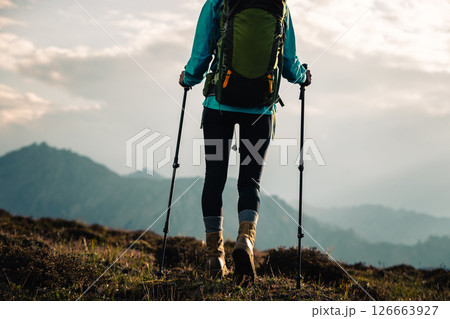 Woman hiking on sunset high altitude mountain top 126663927
