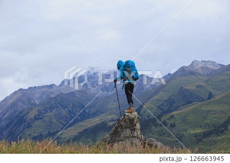 Woman backpacker hiking on high altitude mountain top 126663945