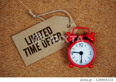 Limited Time Offer text on price tag with alarm clock on cork board background 126664218