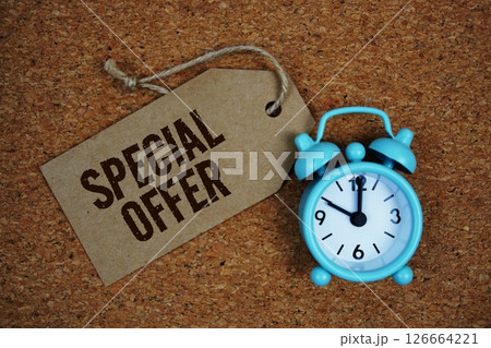 Special Offer text on price tag with alarm clock on cork board background 126664221