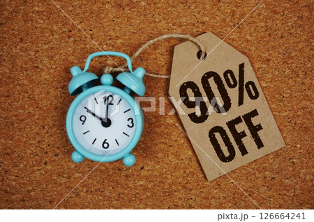 Sale 90% Off text on price tag with alarm clock on cork board background 126664241