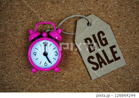 Big Sale text on price tag with alarm clock on cork board background Big Sale text on price tag with alarm clock on cork board background 126664244