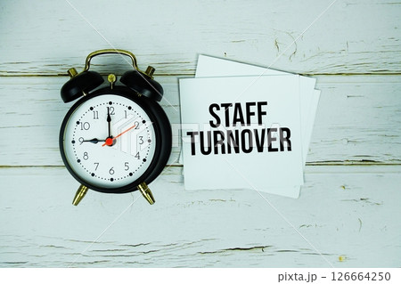 Staff Turnover text message on sticky note with alarm clock on wooden background 126664250