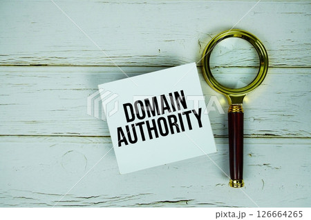 Domain Authority text message on sticky note with magnifying glass on wooden background Domain Authority text message on sticky note with magnifying glass on wooden background 126664265
