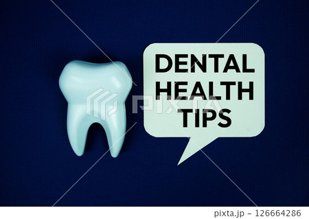 Dental Health Tips text on speech bubble with white tooth model top view on navy blue background, Dental Health Concept Dental Health Tips text on speech bubble with white tooth model top view on navy blue background, Dental Health Concept 126664286