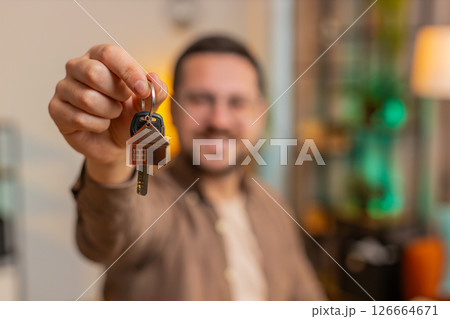 Happy businessman real estate agent using laptop at home office desk showing the keys of new house 126664671