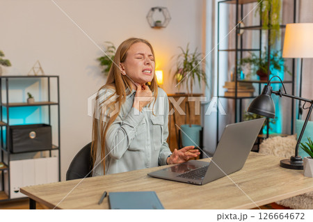 Upset mature Caucasian woman freelancer having sore throat while sitting at home office table desk Upset mature Caucasian woman freelancer having sore throat while sitting at home office table desk 126664672
