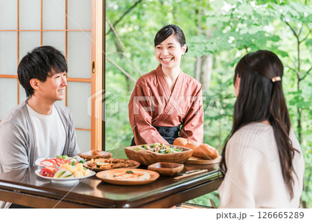 温泉旅館の客室で料理の説明をする旅館スタッフ・仲居さんの女性 126665289