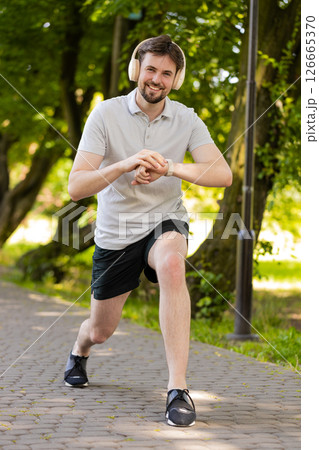 Runner jogger man starting smart watch timer and running checking heart rate monitor before jogging 126665370