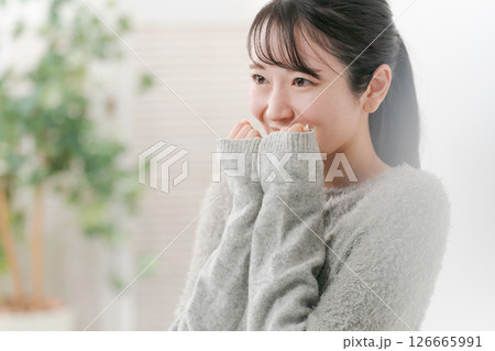 両手の袖で顔を隠す女性 126665991