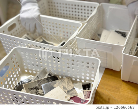 箱に入ったたくさんの白黒写真と白手袋の手元 126666565