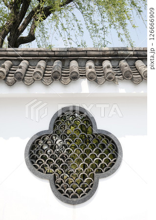 鳥取県 燕趙園 柳の樹の下 塀に施されている曲線を組み合わせた模様の窓と塀瓦 鳥取県 燕趙園 柳の樹の下 塀に施されている曲線を組み合わせた模様の窓と塀瓦 126666909