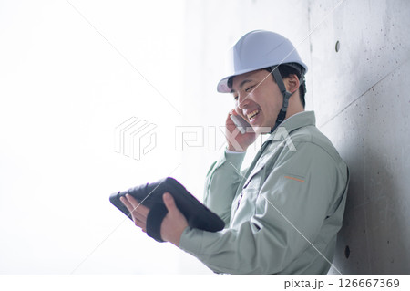 タブレットを持って通話する技術者 タブレットを持って通話する技術者 126667369