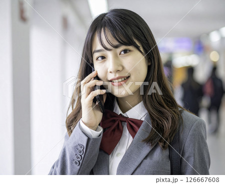 通話中の女子高校生｜学校の廊下での自然な笑顔 126667608