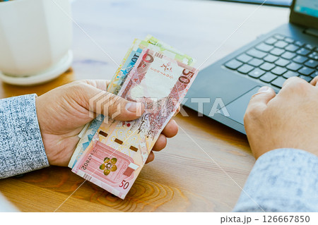Close up of a man's hand counting money Qatar money Close up of a man's hand counting money Qatar money 126667850