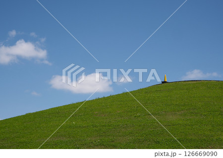 丘の麓から青空と白い雲を見上げる 126669090
