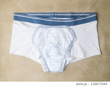 Male incontinence pads on white panties. Incontinence pads for men. Urinary incontinence. Sanitary pads for men with problems of the genitourinary system.  126671044