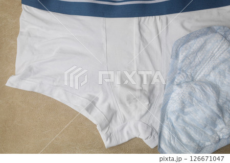 Male incontinence pads on white panties. Incontinence pads for men. Urinary incontinence. Sanitary pads for men with problems of the genitourinary system. Male incontinence pads on white panties. Incontinence pads for men. Urinary incontinence. Sanitary pads for men with problems of the genitourinary system. 126671047
