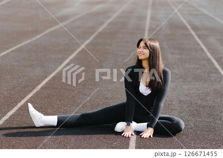 Woman Stretching On Track Field 126671455