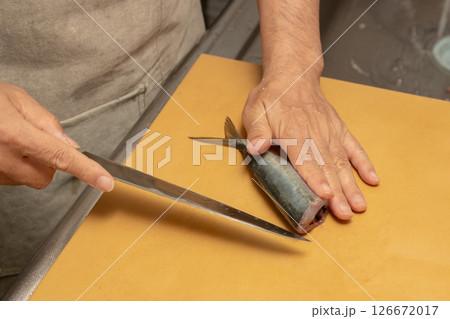 男性が魚のアジをさばいている素材写真 背中から包丁を入れようとしている 男性が魚のアジをさばいている素材写真 背中から包丁を入れようとしている 126672017