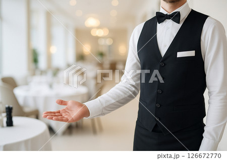 Hotel waiter welcoming guests into restaurant Hotel waiter welcoming guests into restaurant 126672770