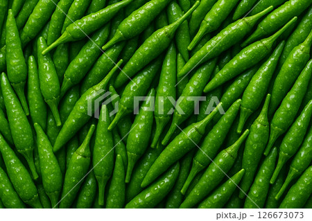 AI generated top view of fresh green chili peppers with water droplets reflecting daylight cleanliness and spiciness in a vibrant and appetizing composition for food or market visuals 126673073