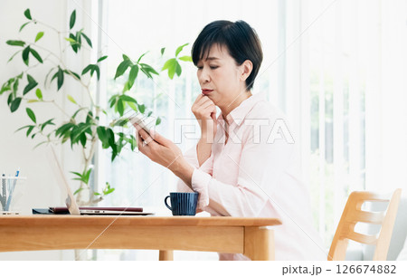 リビングでスマホを操作する中高年女性 リビングでスマホを操作する中高年女性 126674882