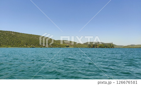 Visovac monastery island on krka river reflecting on turquoise water in croatia Visovac monastery island on krka river reflecting on turquoise water in croatia 126676581