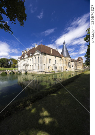 Chateau de Commarin reflecting on the moat under blue sky in Bourgogne Franche Comte, France 126676827