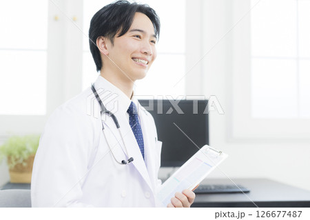 診察室で話す白衣の男性 126677487