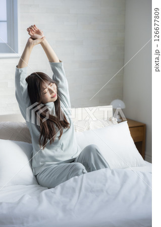 ベッドで伸びをする女性 126677809