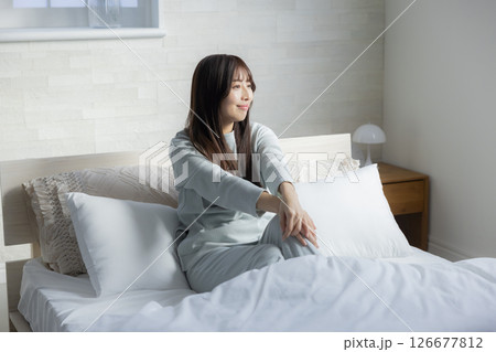 ベッドで伸びをする女性 126677812