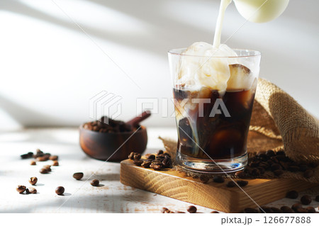 アイスコーヒーに注がれる冷たいミルク 126677888