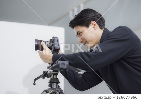 動画撮影をするカメラマンの男性  126677966