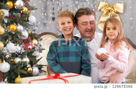 Dad with son and daughter on sofa in Christmas interior 126678566