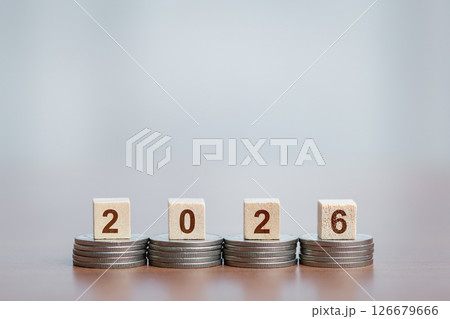 Stacked Coins Supporting Wooden Blocks Showing '2026', Financial Growth and Future Planning Concept 126679666