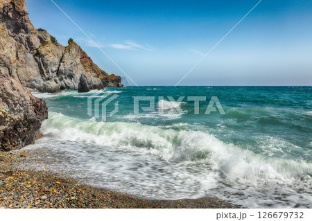 Amazing view of sea waves crashing on the shore and flowing above seashore pebbles 126679732