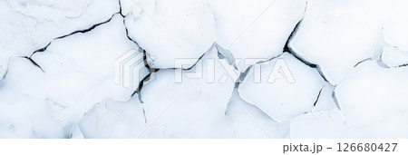 Dry, cracked earth creating intricate patterns under bright sunlight, emphasizing the profound effects of climate change and drought on the fragile environment 126680427