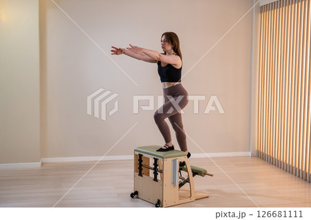 Asian woman doing pilates classic chair.  126681111