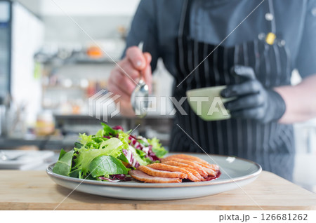 The chef serves roast duck.  126681262