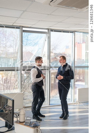 Two Caucasian men talking at work in the office.  126681346