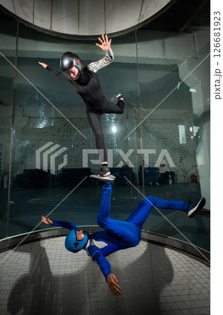 A man and a woman enjoy flying together in a wind tunnel. Free fall simulator A man and a woman enjoy flying together in a wind tunnel. Free fall simulator 126681923