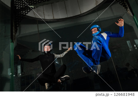 A man and a woman enjoy flying together in a wind tunnel. Free fall simulator 126681948