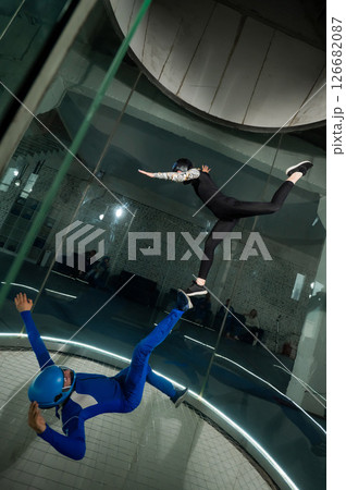 A man and a woman enjoy flying together in a wind tunnel. Free fall simulator 126682087